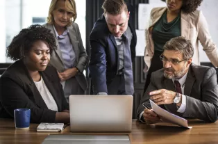 Personer diskuterar och tittar på gemensam datorskärm